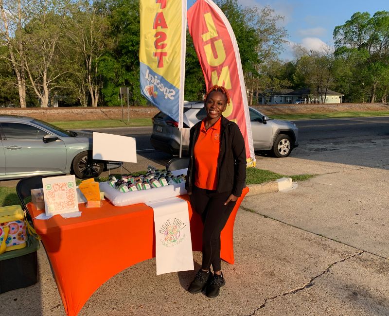 Shardai standing in front of a display of cold pressed juice
