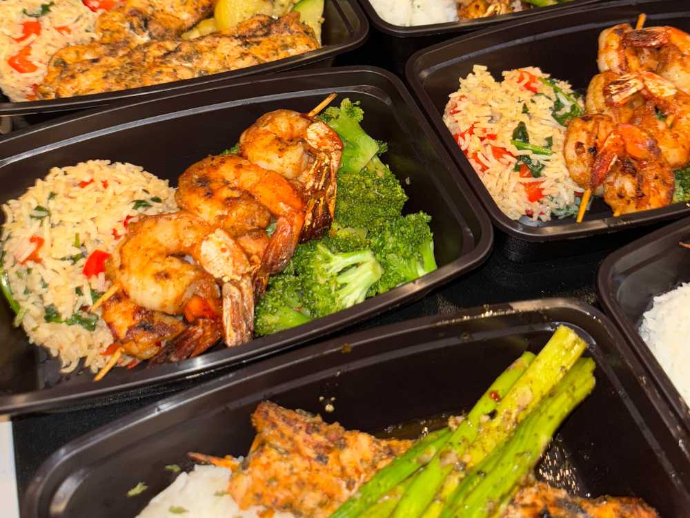 Meal prep bowls with shrimp skewers, rice, and broccoli