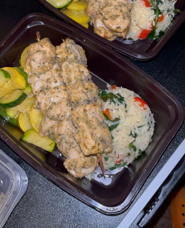 Meal prep bowl with chicken skewers, rice, and zucchini